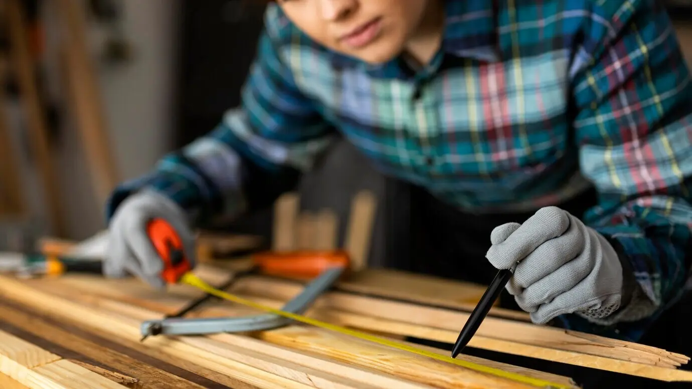 Woman measuring wooden planks