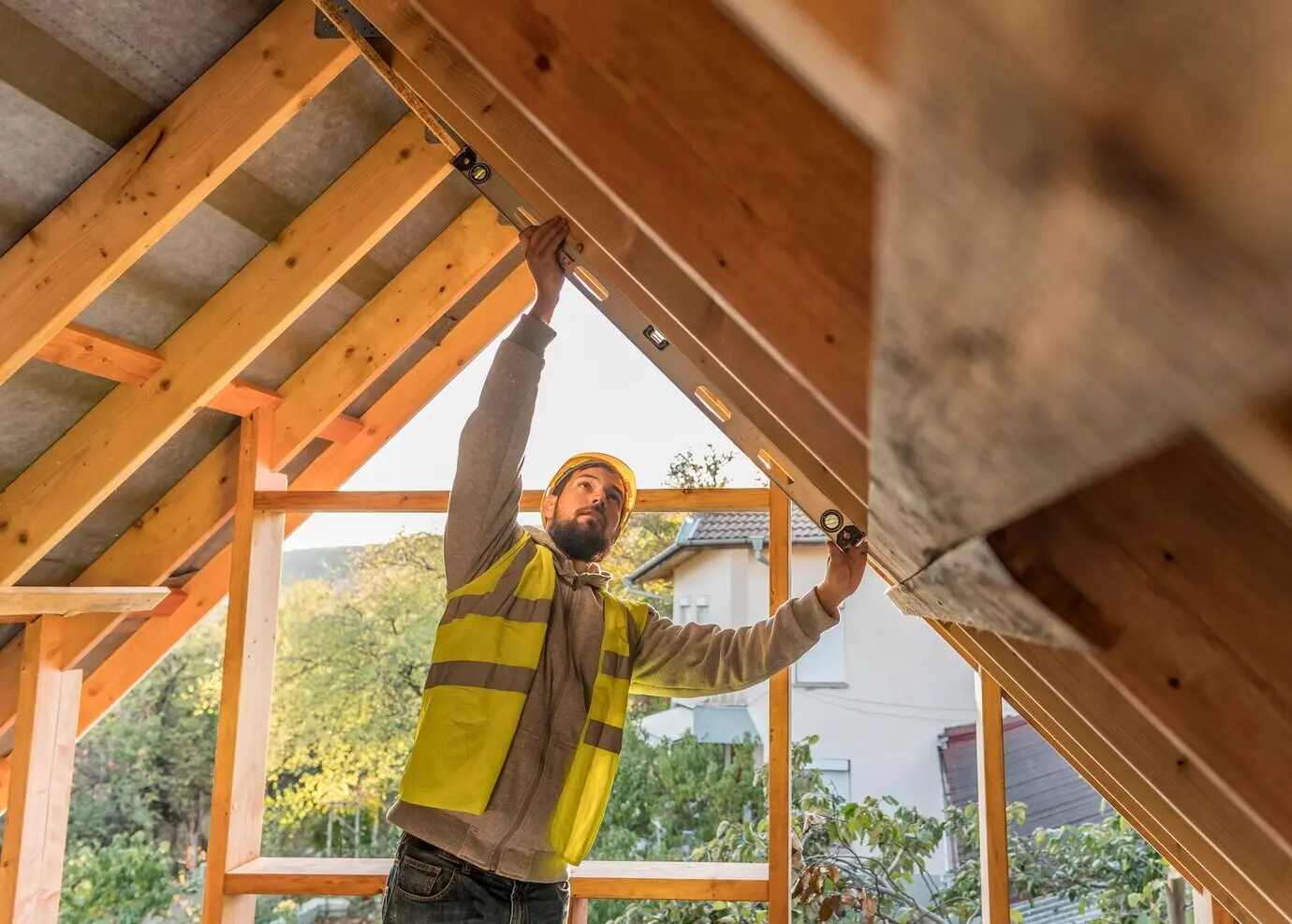 A male carpenter working on a roof.